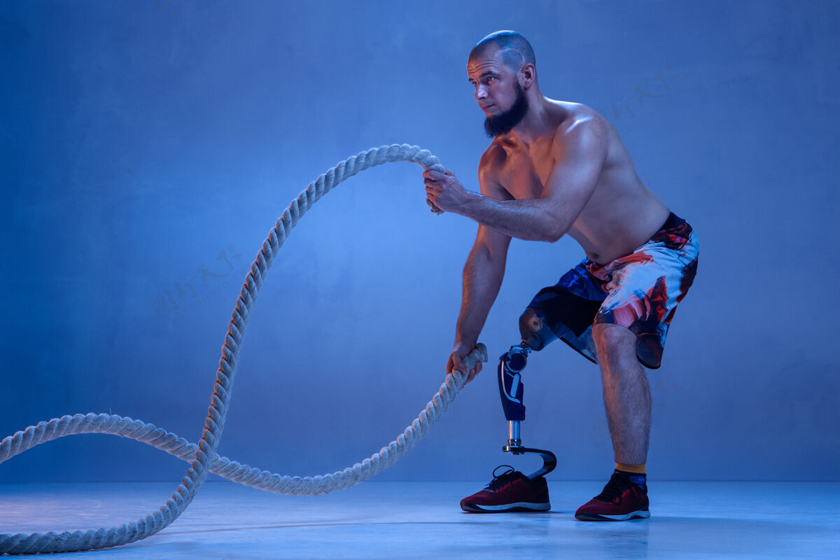 问题专业男子运动员与腿假肢训练与绳索在霓虹灯物理人男性
