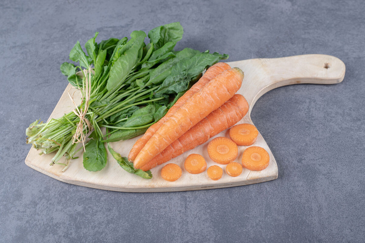 美味把豆瓣菜和胡萝卜放在砧板上 放在大理石表面上生的美味板