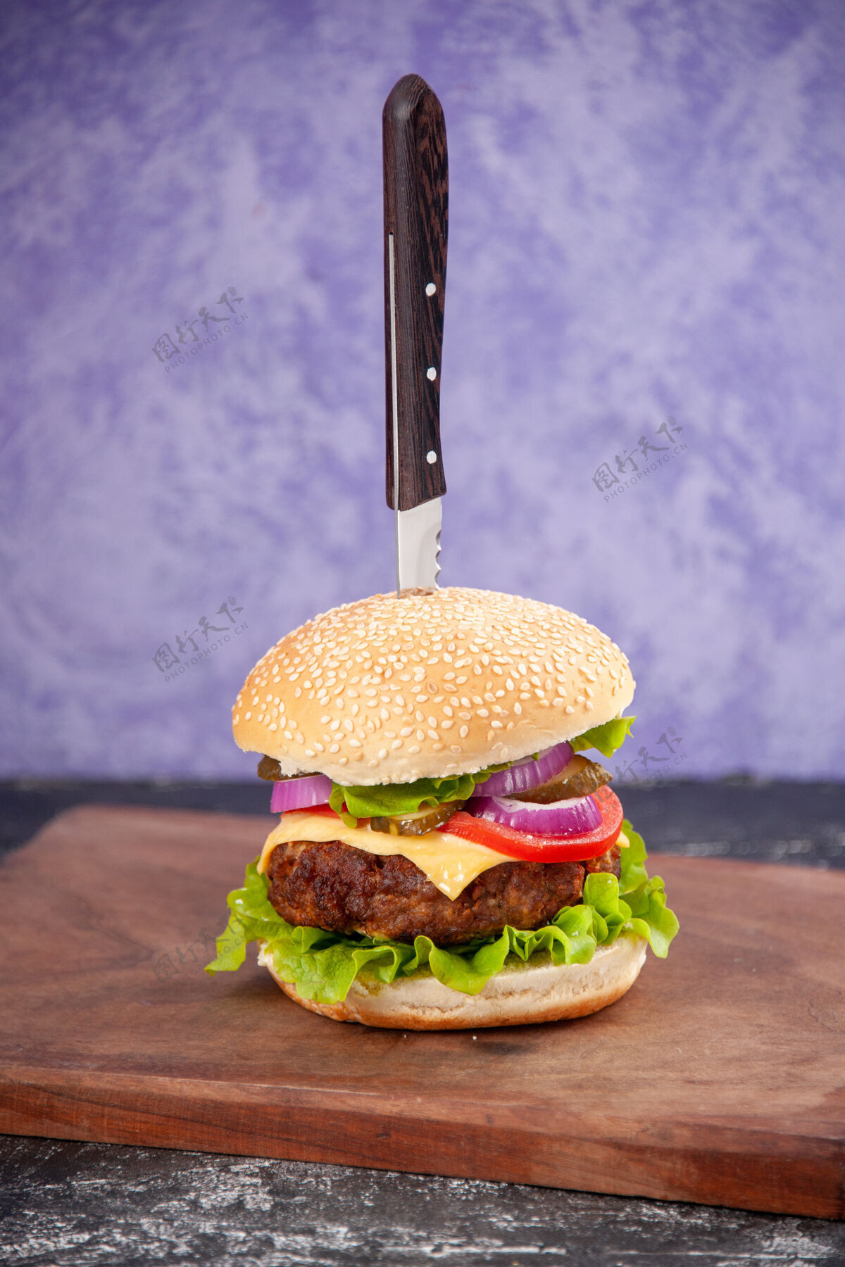 芝士汉堡特写镜头刀在美味的肉三明治在木制切割板上孤立的冰面与自由空间板三明治冰