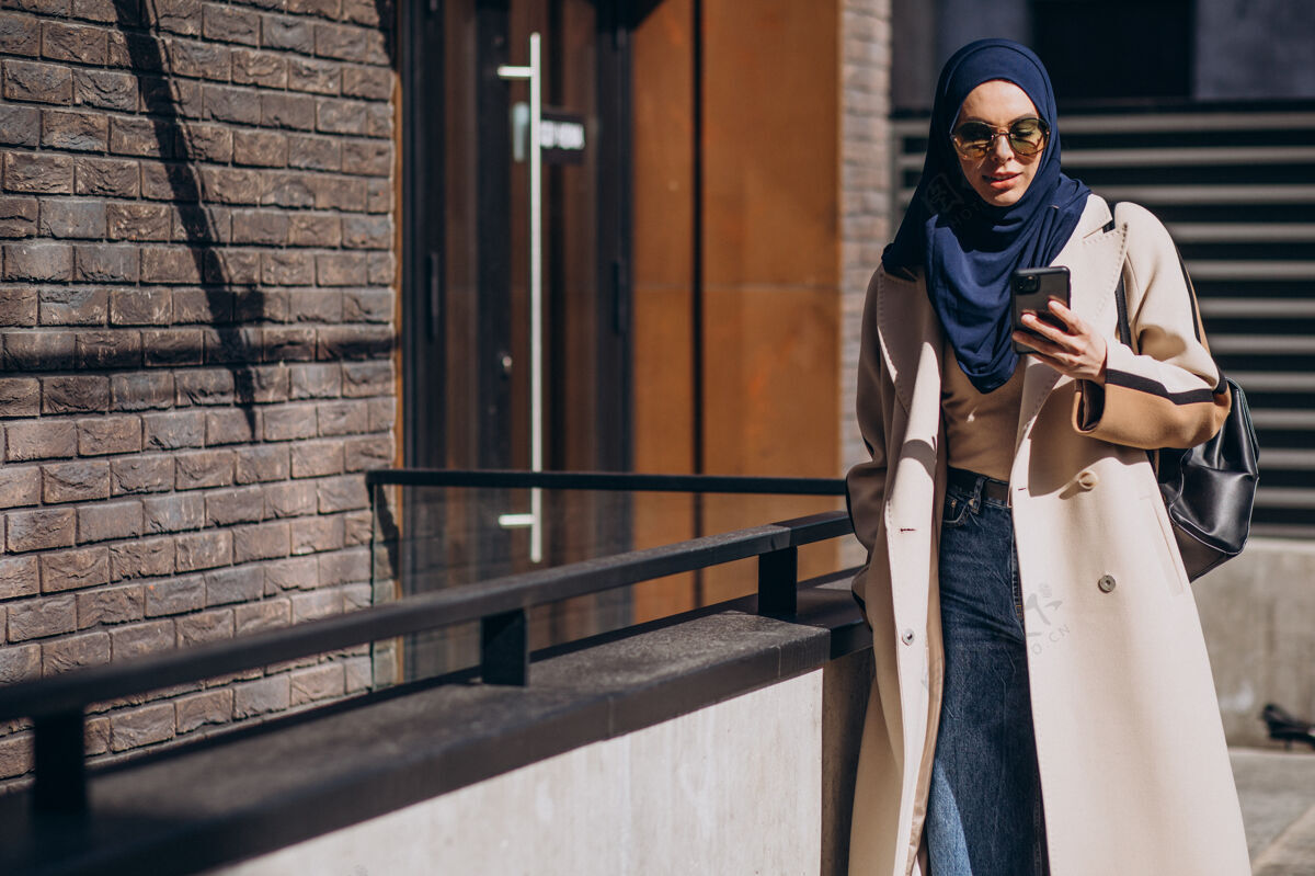 围巾现代穆斯林妇女在打电话头巾伊斯兰手机