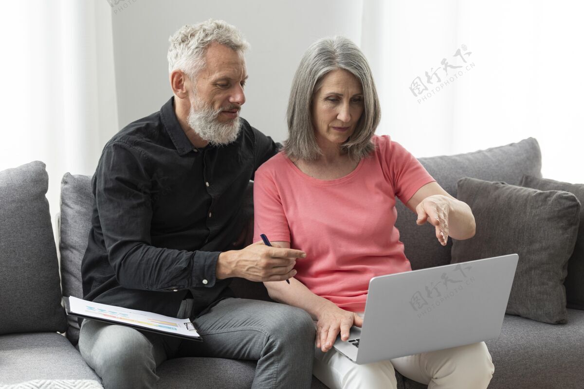 女人老两口在家沙发上用笔记本电脑水平室内妻子