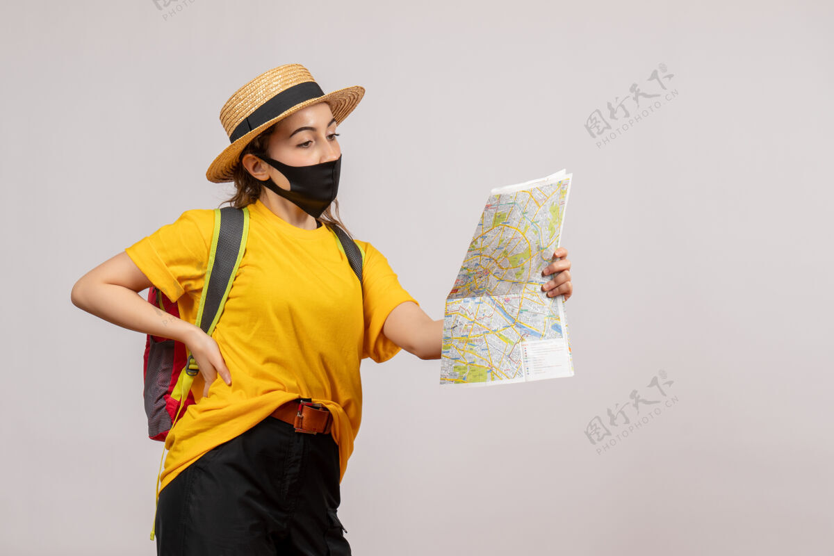 年轻旅行者正面图年轻的旅行者背着背包看地图 手放在腰上面罩旅游腰