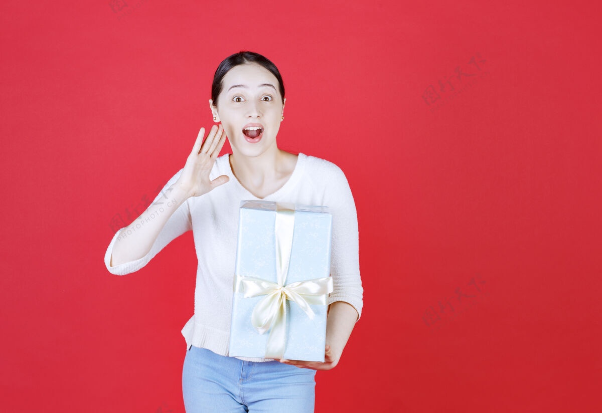 举行快乐的年轻女子拿着礼盒说着什么礼物人微笑