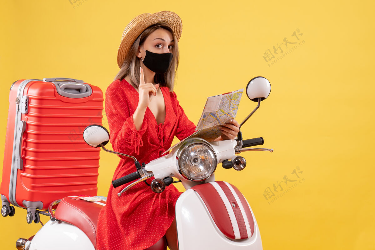 度假正面图：戴着黑色面具的年轻女士拿着地图惊讶地想到了一个靠近轻便摩托车的主意冒险面具流行病