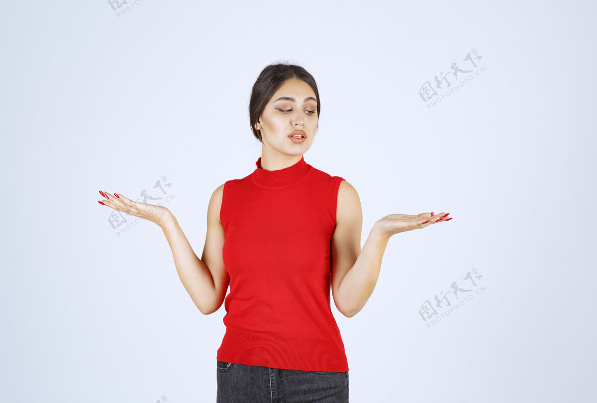 人穿红衬衫的女孩在她张开的手上展示着什么人介绍休闲