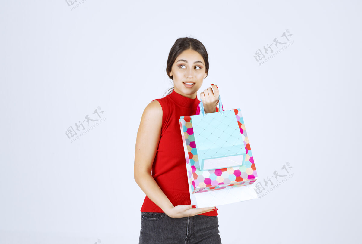 模特带着五颜六色购物袋的女孩感觉很积极员工微笑常规