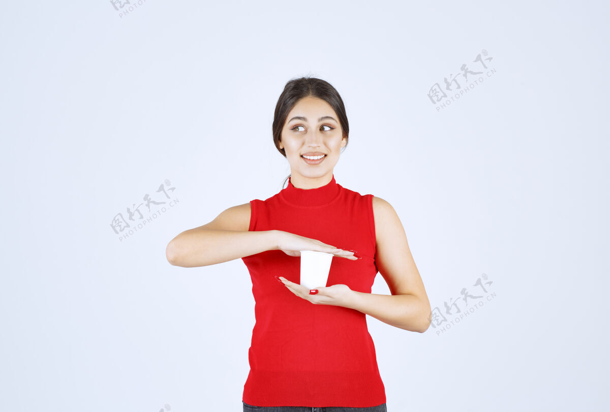 女人一个穿红衬衫的女孩双手捧着一个白色的咖啡杯女性职员服装