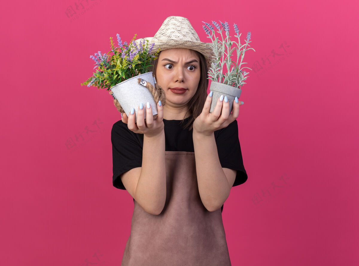 园艺迷茫美丽的白人女园丁戴着园艺帽拿着花盆迷茫女戴着