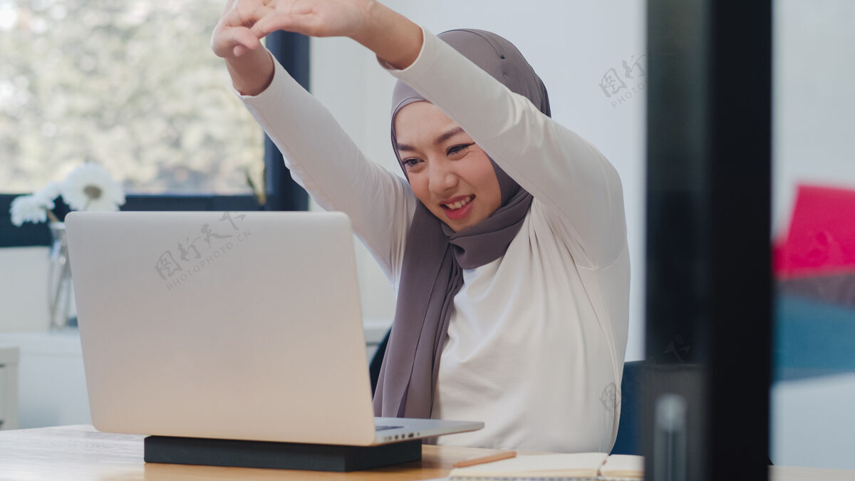 笔记本电脑美丽的亚洲穆斯林女士休闲装 在现代新常态办公室使用笔记本电脑工作阿拉伯语商业技术