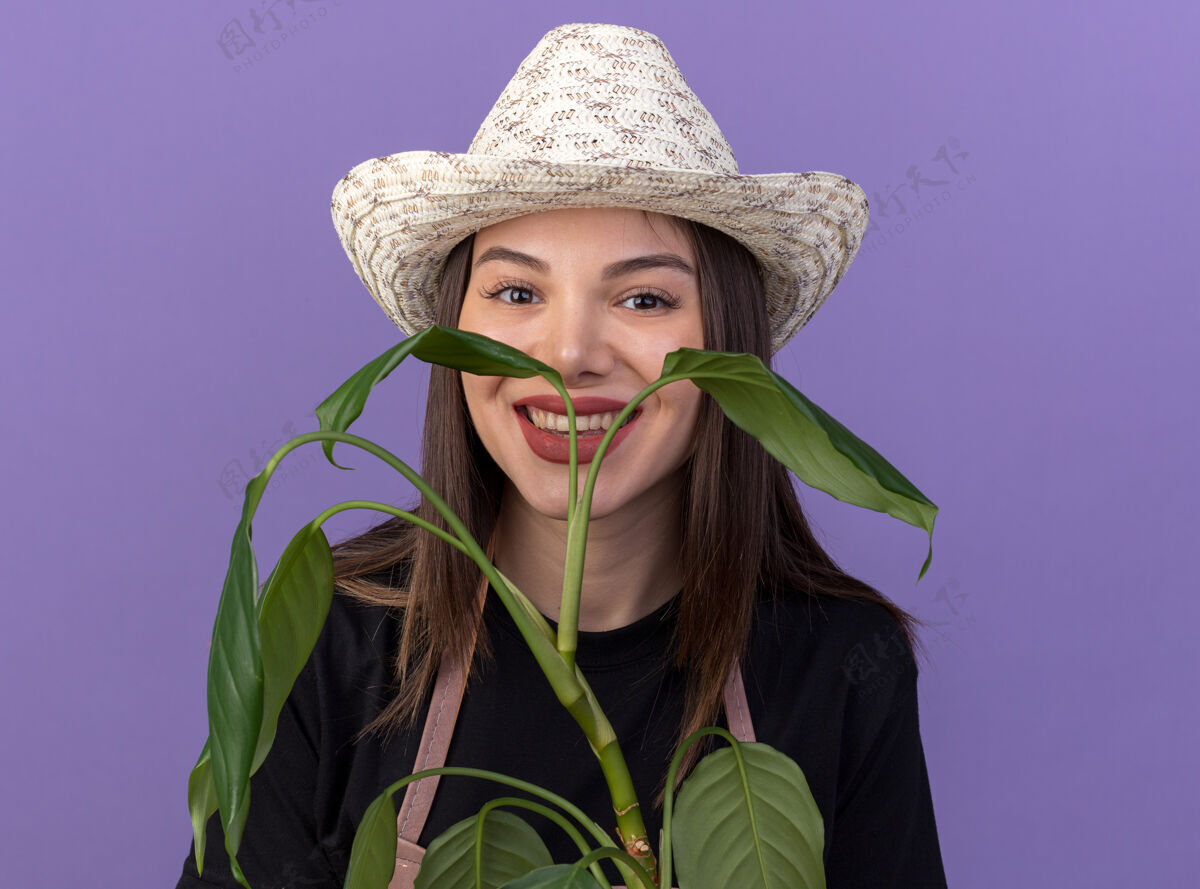 园艺笑容可掬的高加索女园丁戴着园艺帽捧着植物枝帽子微笑女