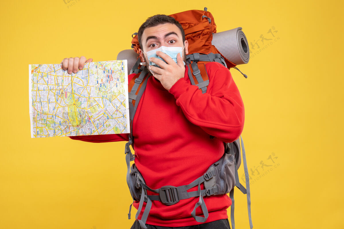 人物顶视图一个旅行者家伙戴着医疗面具和背包举行黄色背景地图麦克风人物设备