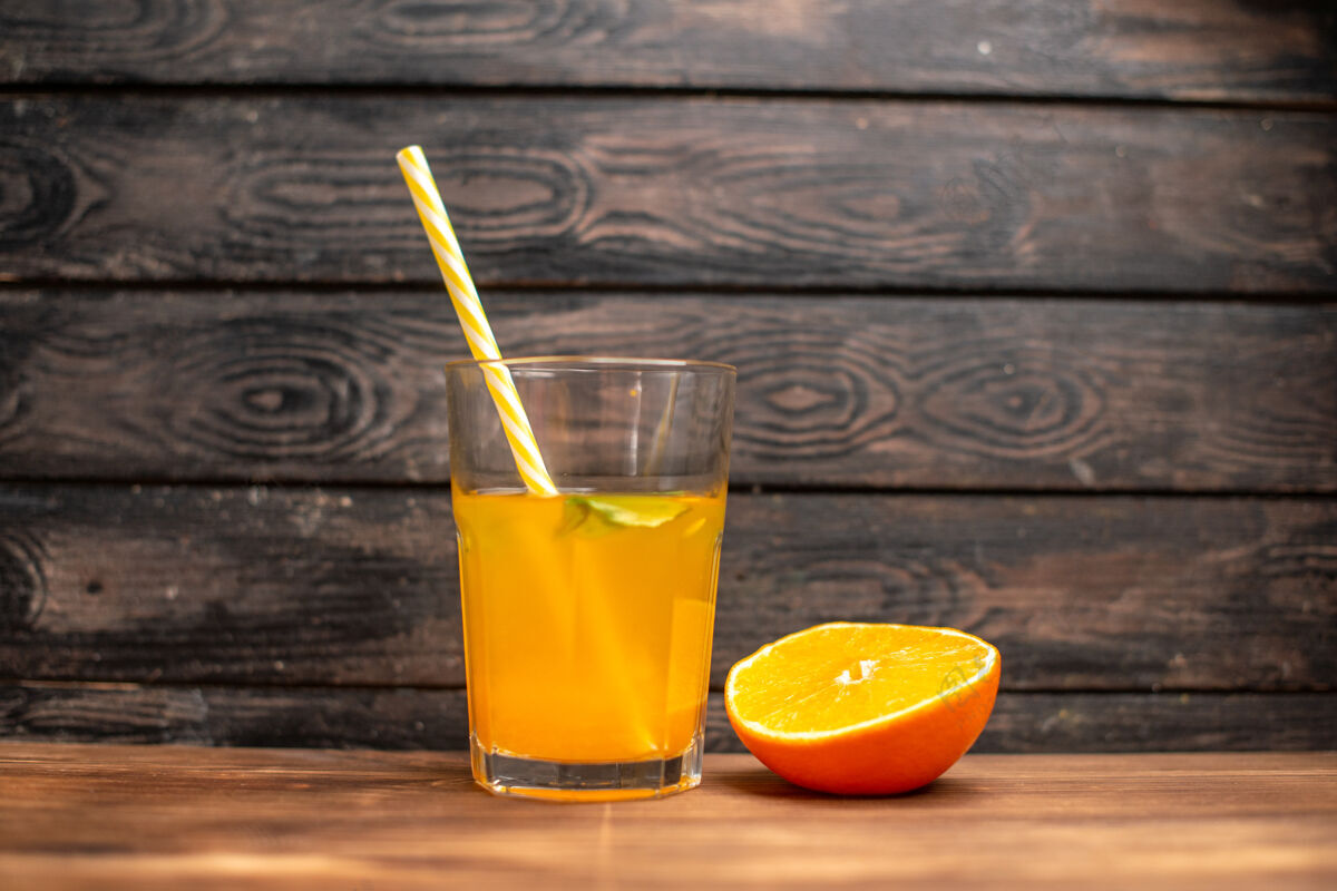 玻璃木桌上放着一杯鲜橙汁 上面放着薄荷和橙黄刷新液体餐桌
