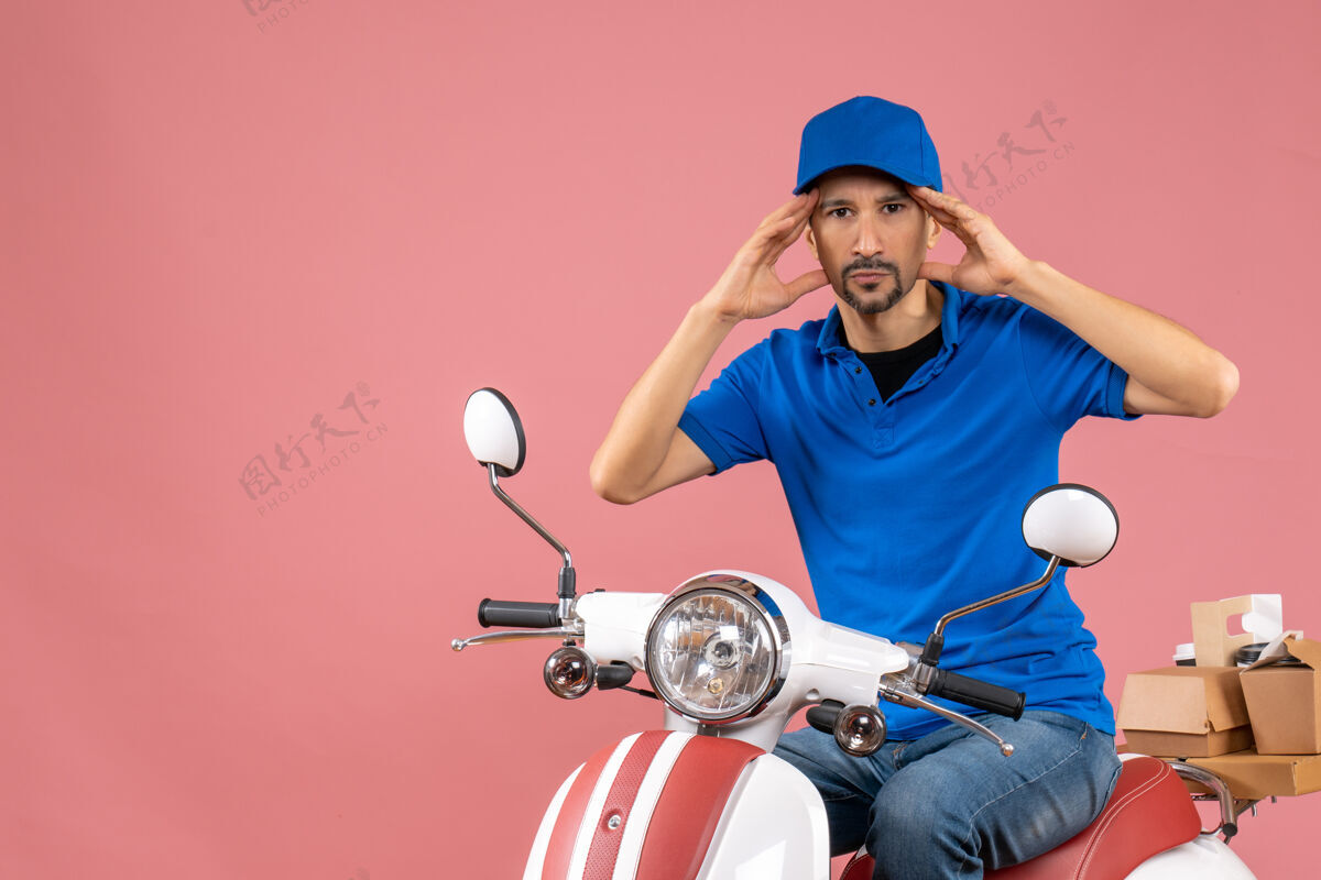 粉彩前视图集中快递家伙戴着帽子坐在滑板车上粉彩桃背景桃头盔微笑