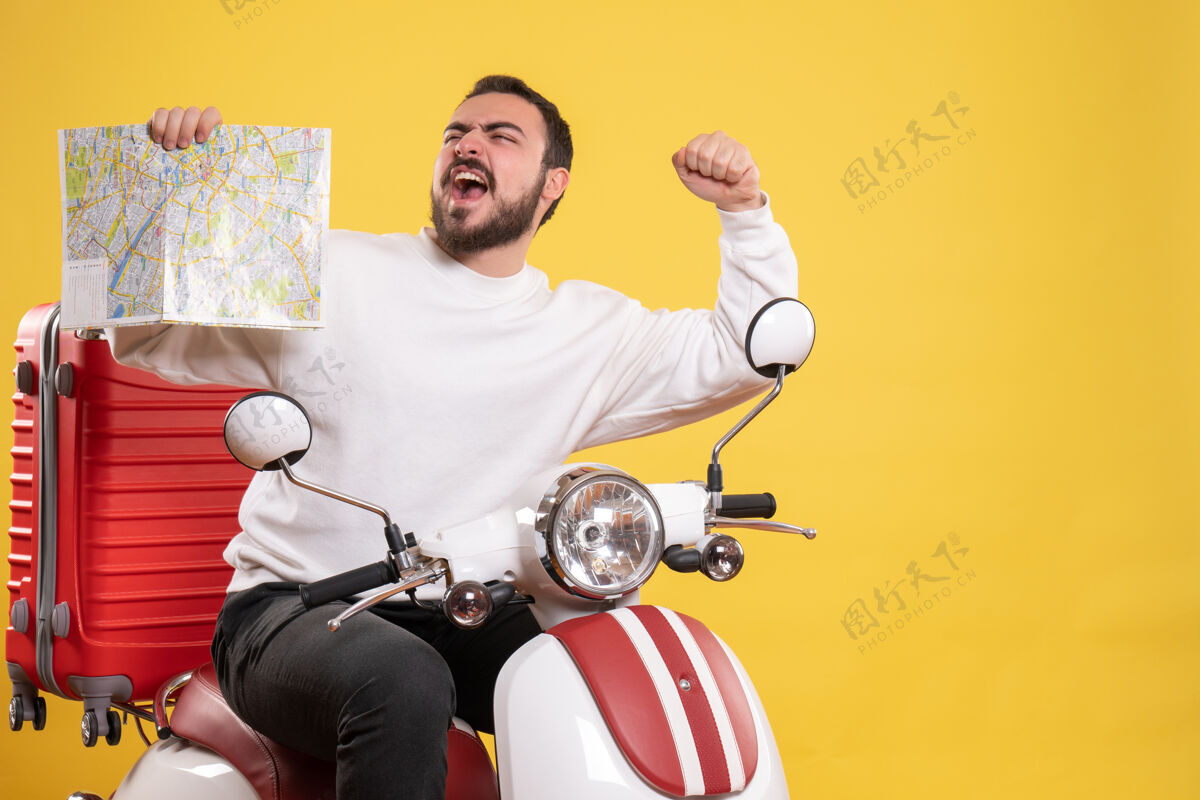手提箱旅行概念与自豪的家伙坐在摩托车上 手提箱上显示黄色地图黄色旅行人