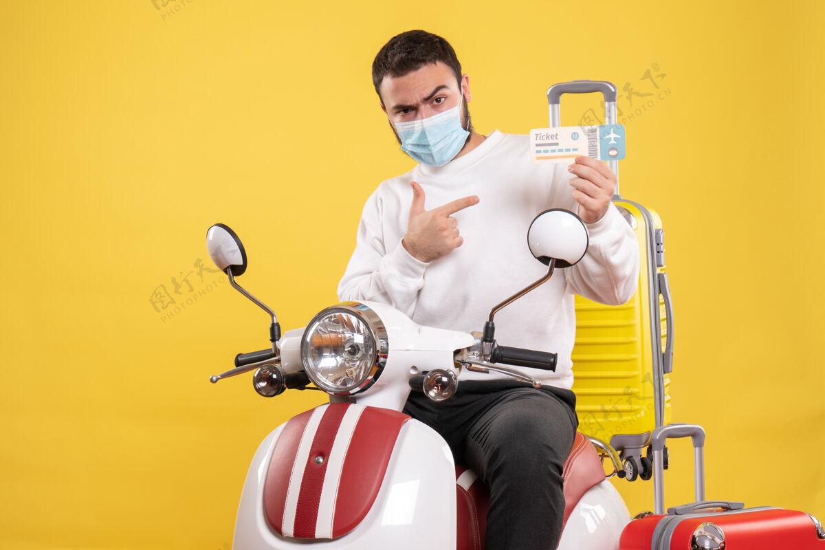 面罩带着医用面罩的年轻野心勃勃的家伙坐在摩托车上 俯瞰旅行概念坐人运动