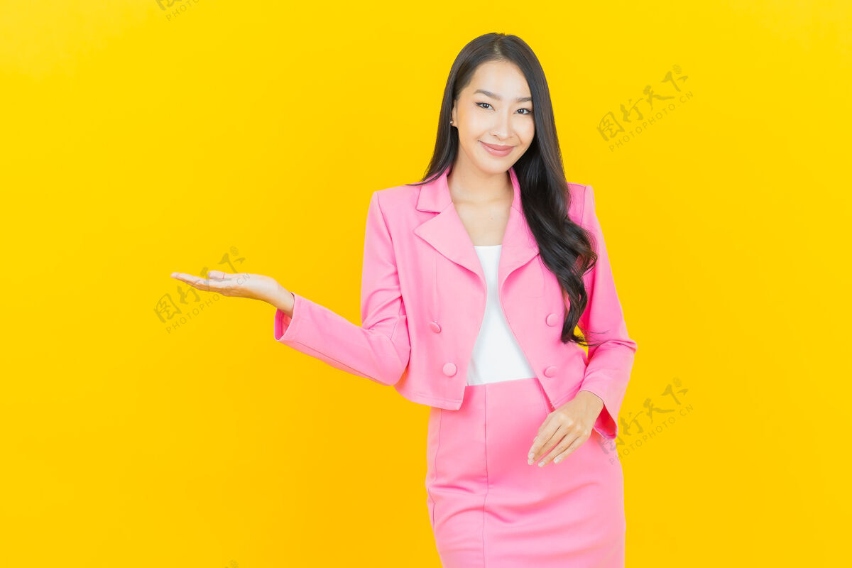 多彩在黄色墙壁上描绘美丽的亚洲年轻女子微笑的动作休闲亚洲人明亮