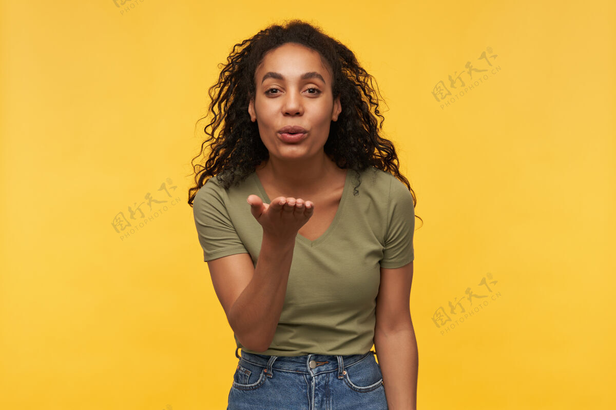 欢呼年轻快乐快乐的非洲裔美国女人 把空气吻进镜头 感觉很快乐穿着绿色t恤和蓝色牛仔裤表情女人外观