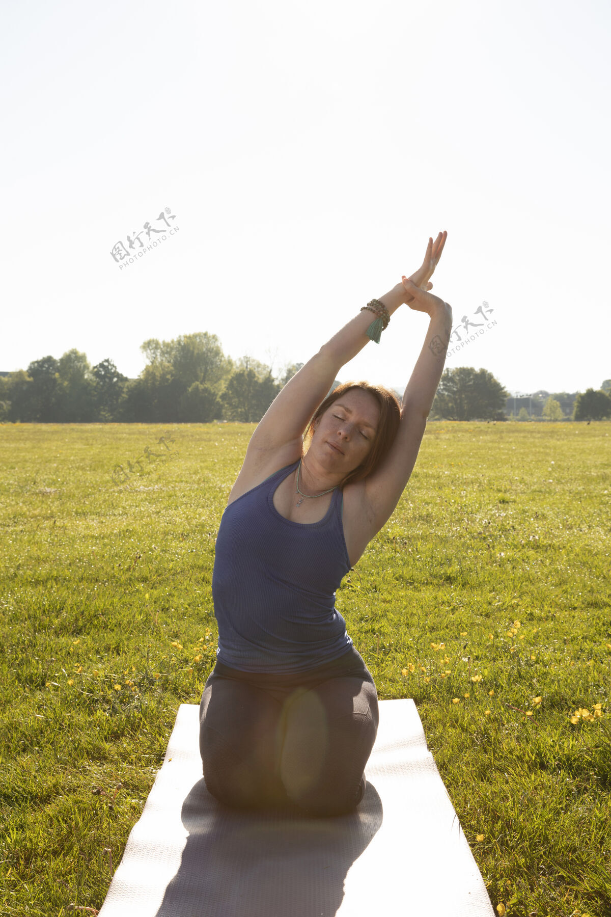 反思年轻女子在户外瑜伽垫上冥想垂直运动外部