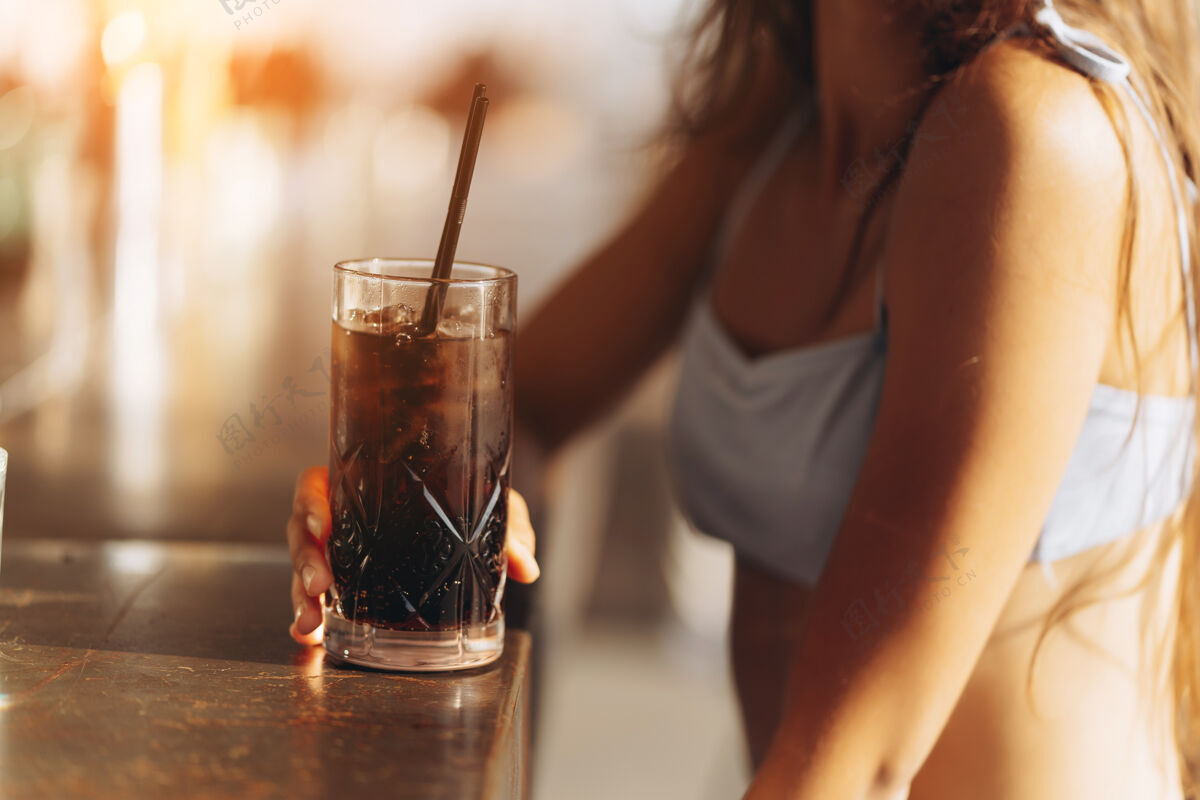 度假村在沙滩酒吧休息的女人喝一杯清爽的鸡尾酒俱乐部女性女士