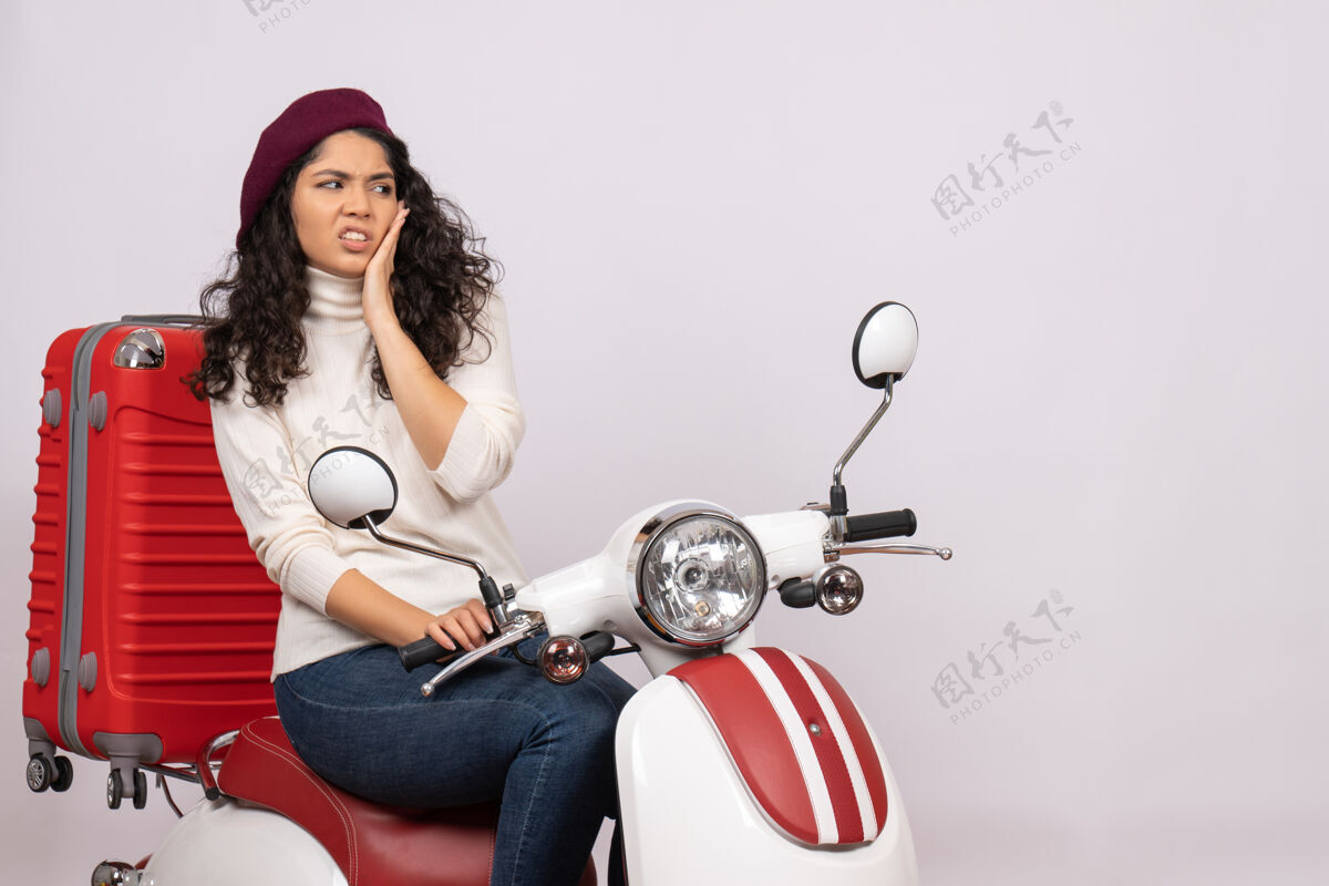 摩托车正面图年轻女子骑在白色背景的自行车上车速极快彩色假期摩托车上路的女人成人自行车人