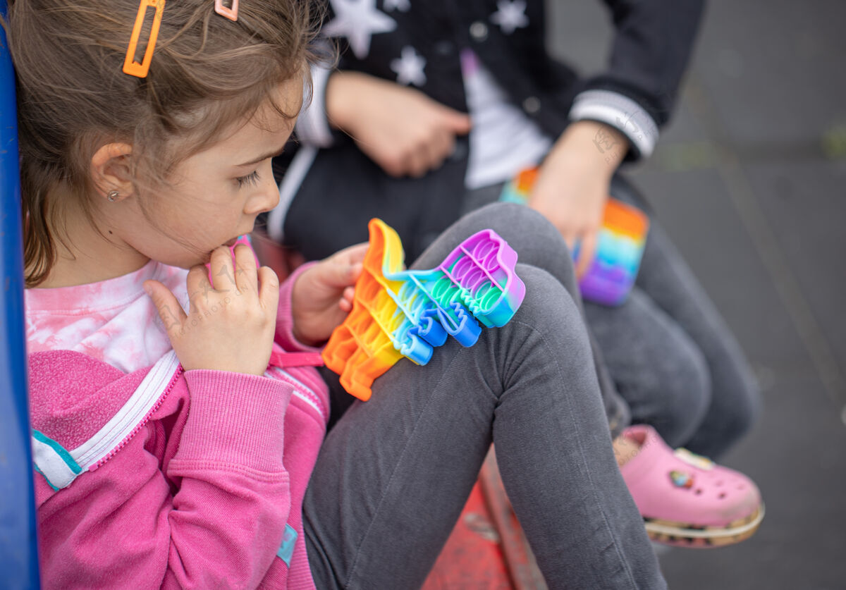 乐趣小女孩们玩一种深受孩子们欢迎的新玩具 可以帮助她们集中注意力泡泡娱乐压力