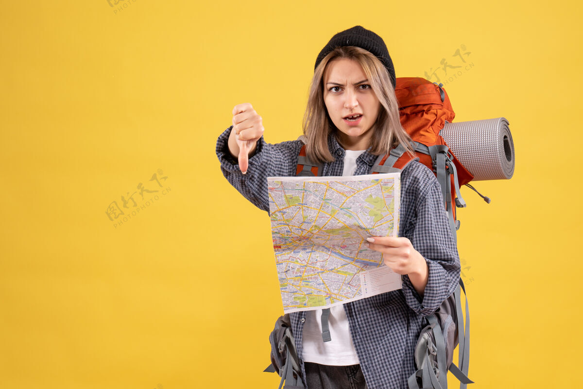 拇指背着背包拿着地图的女旅行者竖起大拇指人女旅客肖像