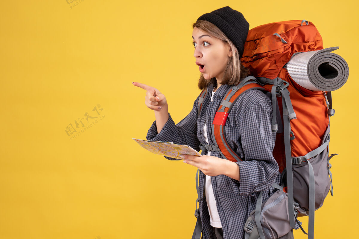 女士背着背包拿着地图的困惑的年轻旅行者衣服模特黑色