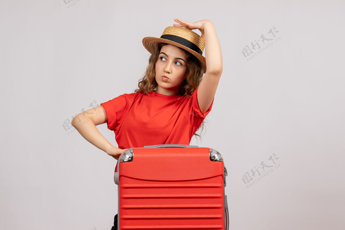 休闲漂亮的年轻女人 她的手提箱站在白色的地板上人女士站立