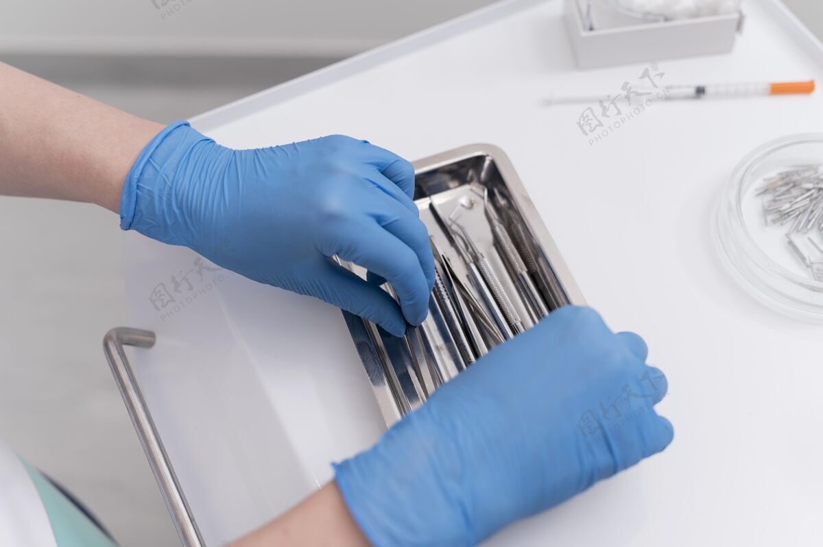 从业者戴着乳胶手套的正畸医生正在处理牙科设备雇员就业关键工人