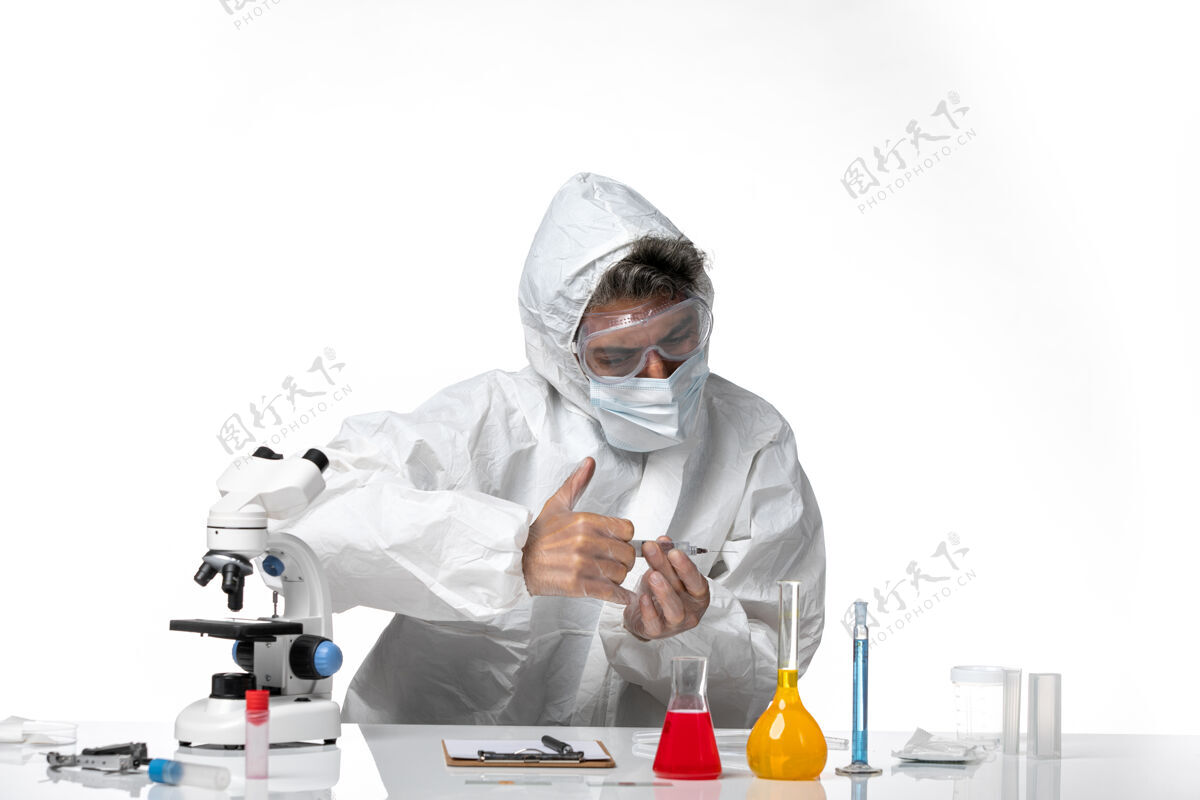 灭菌男医生穿着防护服 带无菌口罩 在浅白色皮肤上注射男人视图医生