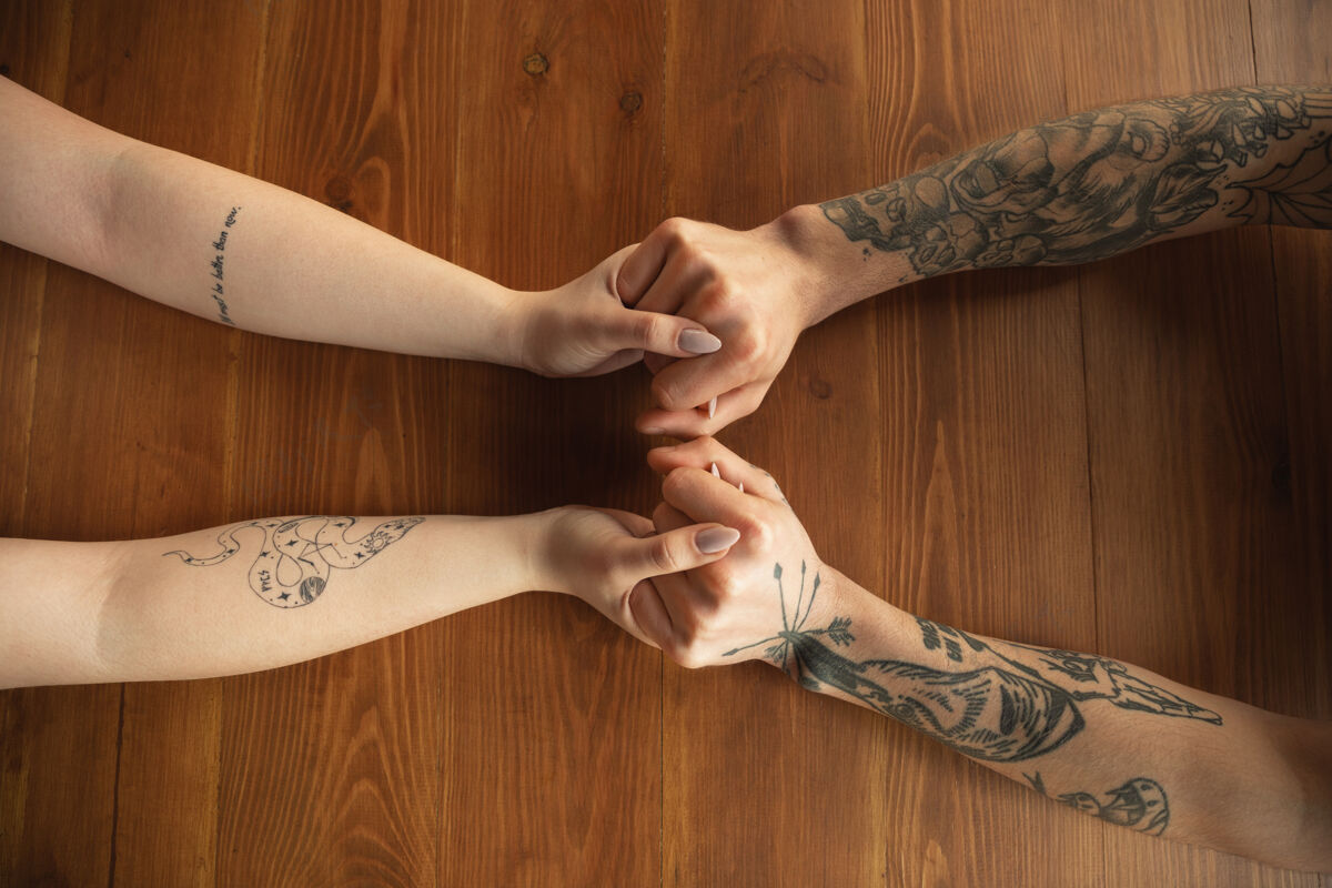 手臂可爱的白种人情侣手拉手在木制背景上特写浪漫 爱情 关系 温柔的触摸白对顶视图