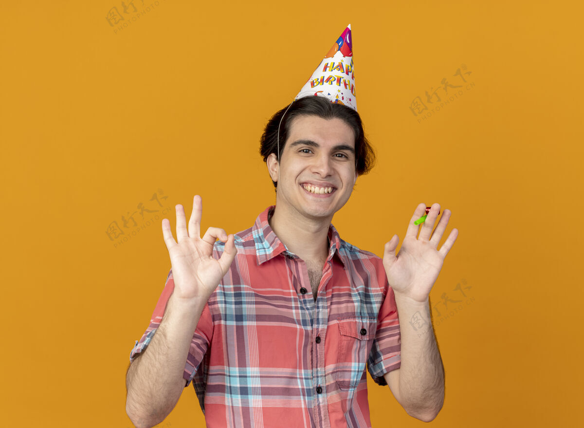 生日笑容可掬的白人帅哥戴着生日帽手势ok手势并手持派对哨子手势手穿