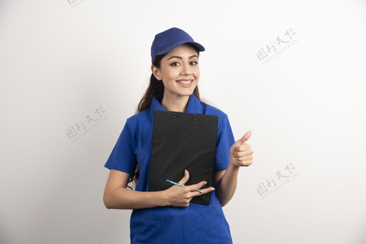 立场年轻的女快递员拿着一张高质量的照片平板电脑剪贴板工人