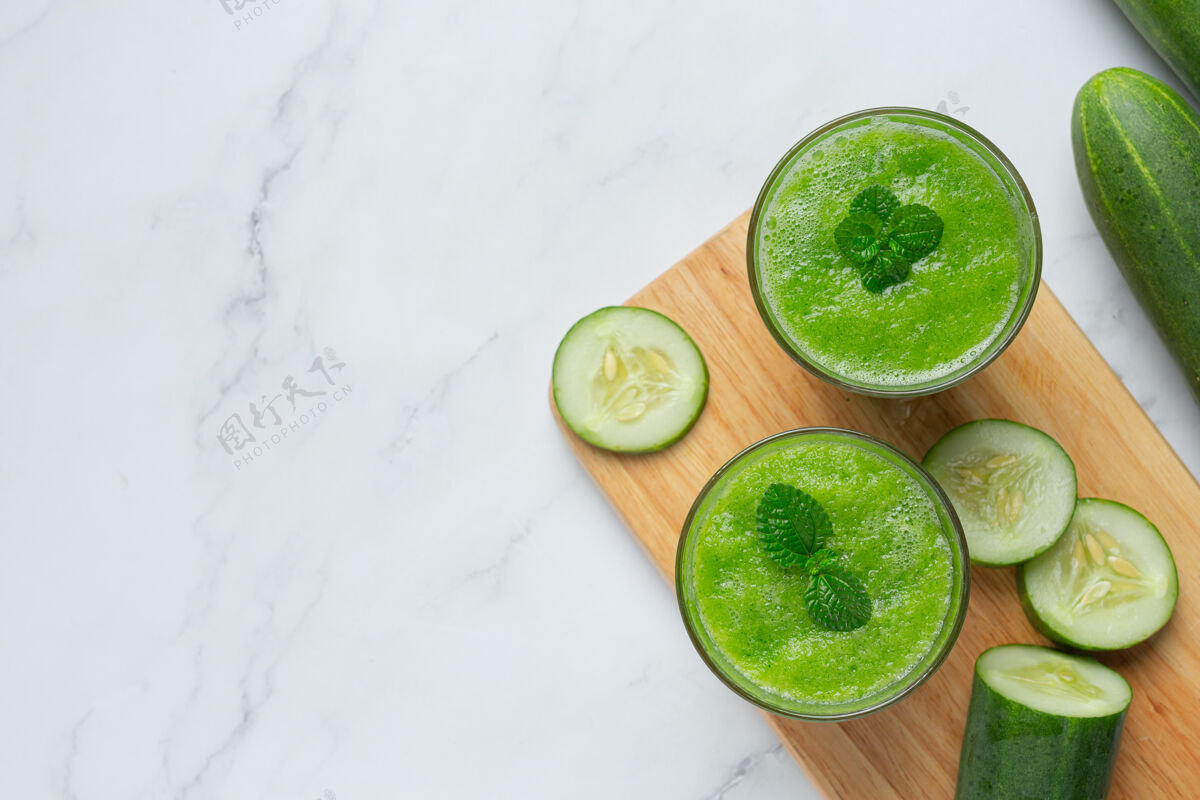 绿色一杯新鲜黄瓜汁放在大理石背景上冰沙白色桌子