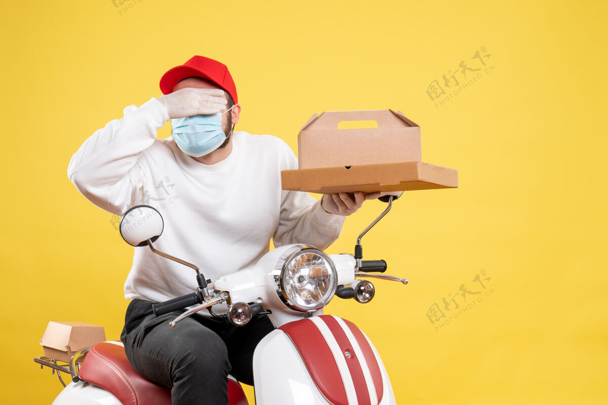 摩托车戴着面具的男快递员拿着黄色的快递食品面罩男信使头盔