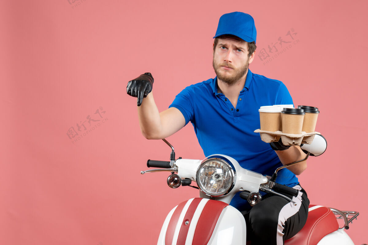 拿着正面图男性信使坐在自行车上拿着咖啡杯在粉红色坐着男信使工作