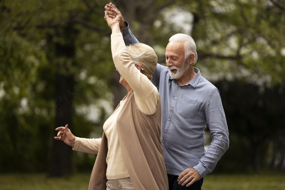 关系中景高级夫妇在公园跳舞浪漫老年家庭