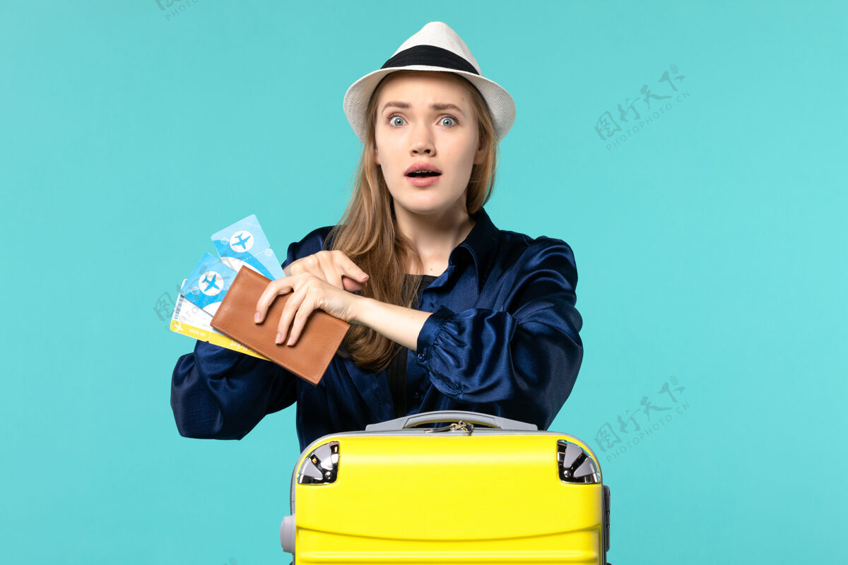 成人正面图年轻女子拿着机票 准备在蓝色地板上度假旅行航海飞机度假人年轻女子职业