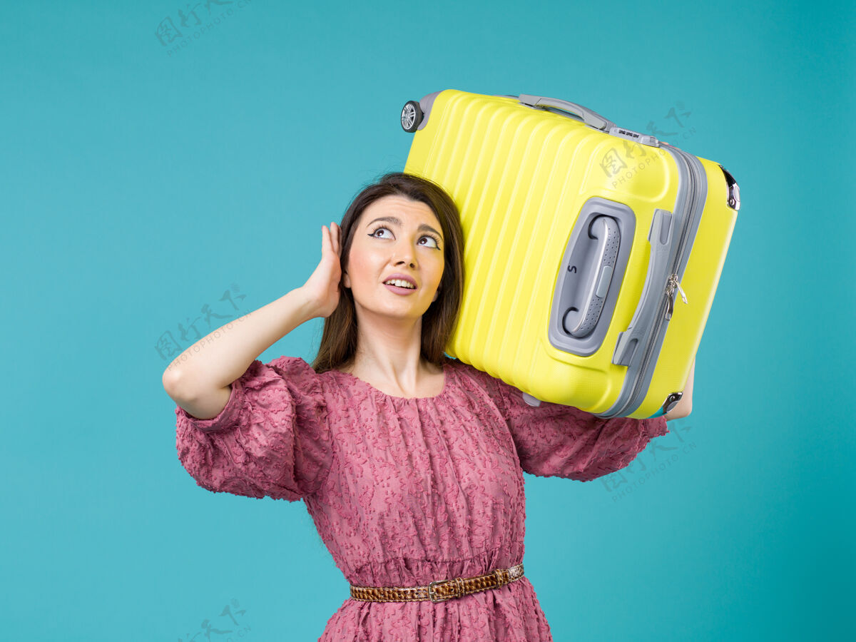 旅途正面图年轻女子带着蓝色背景的黄包去度假夏日旅行女子海上度假旅行人女士年轻女子