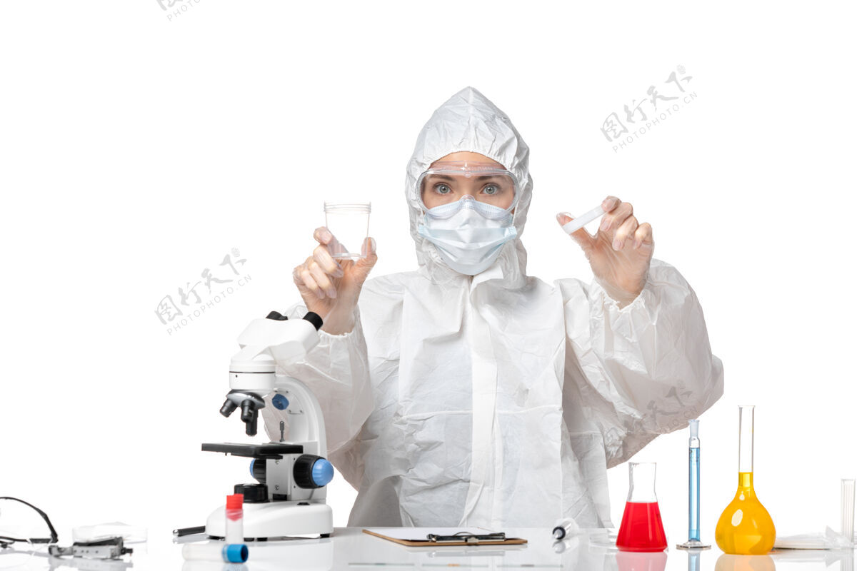 保温瓶正面图：年轻女医生穿着防护服 戴着口罩 白色背景上有一个装着柯维德病毒的瓶子 溅起大流行的柯维德病毒专业医生套装