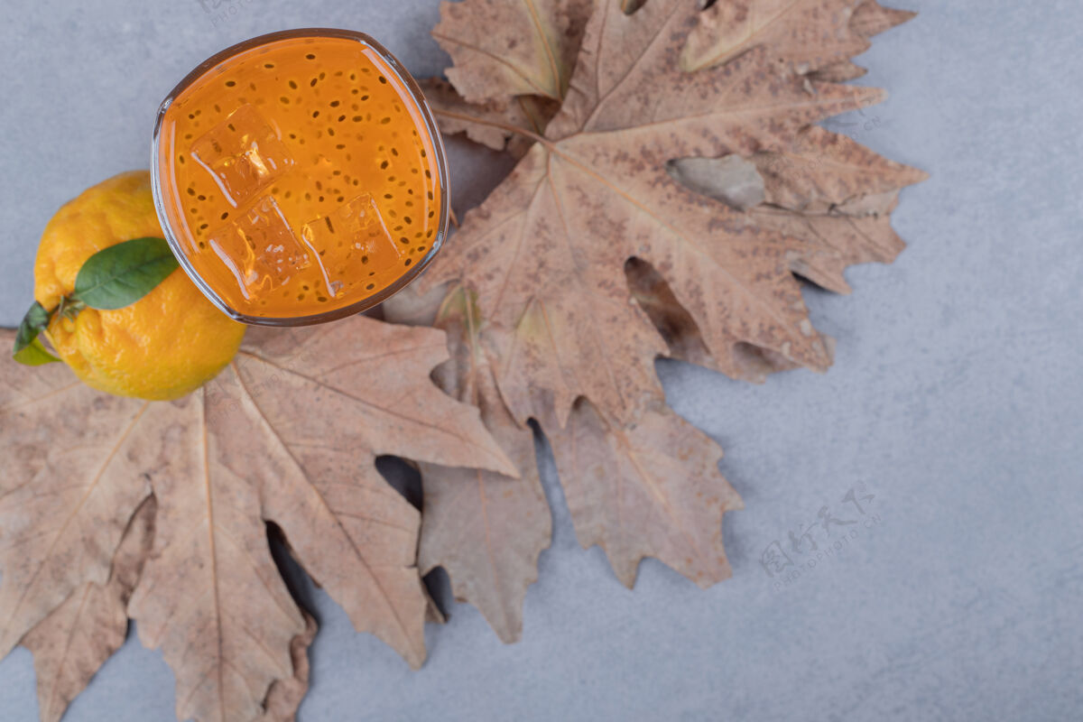 饮食橘子汁和新鲜橘子在灰色地面上干叶的俯视图提神玻璃开胃酒