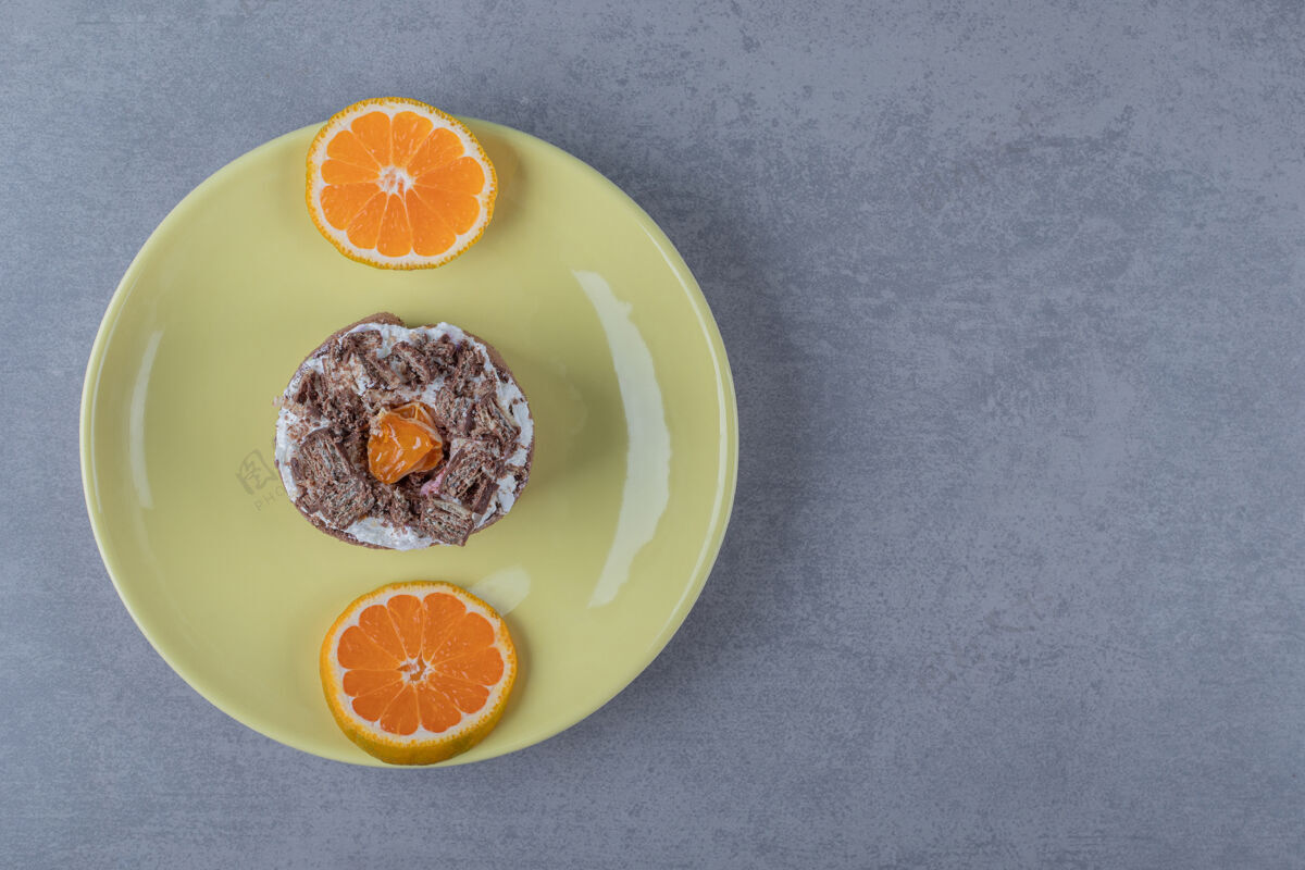 烘焙新鲜奶油松饼 黄色盘子上放橘子片美味饼干自制
