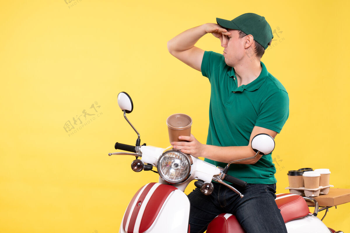 车辆正面图身着制服的男信使拿着黄色的咖啡杯持有送货输送机