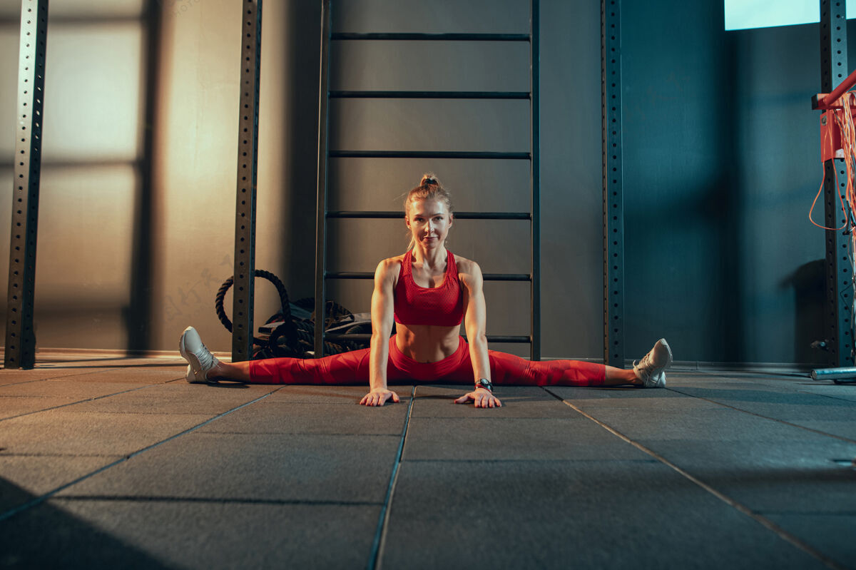 活跃年轻肌肉发达的女人在健身房练习能量女性运动