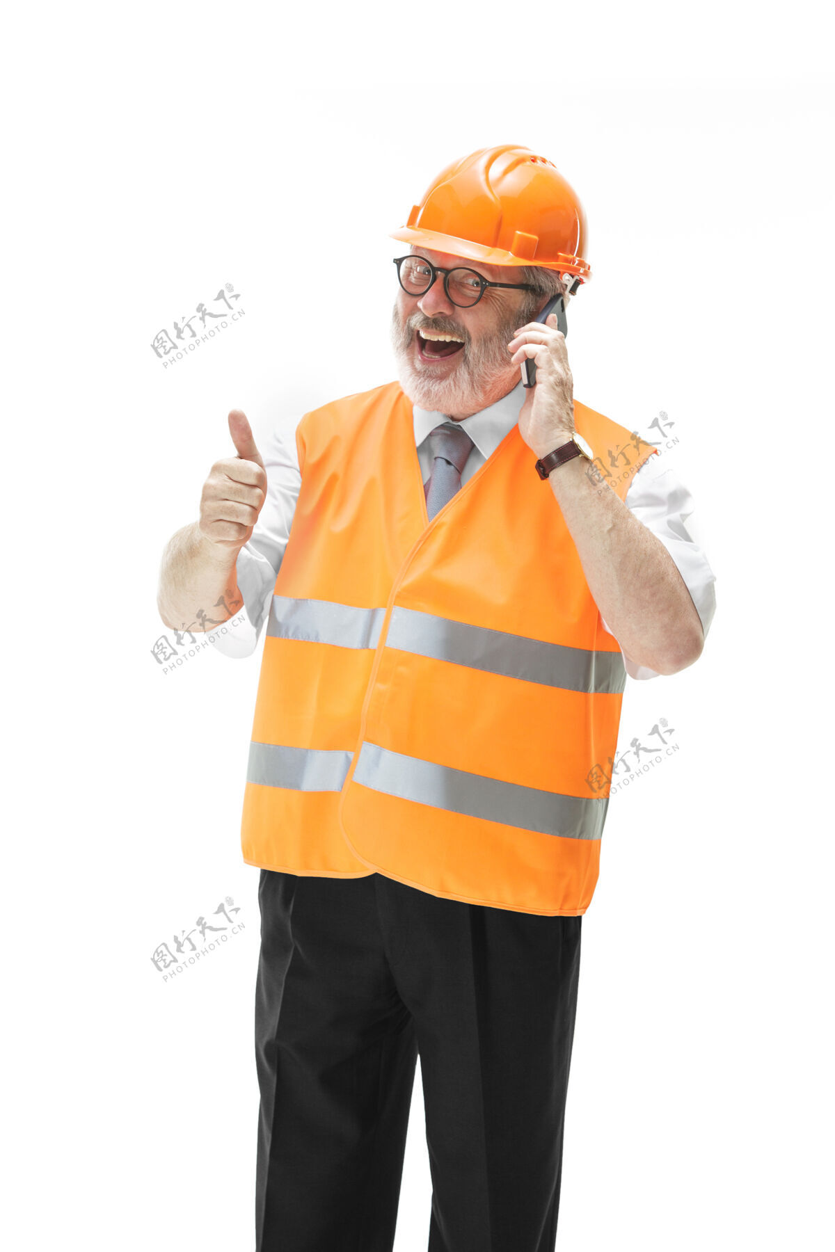 男性一个穿着建筑背心 戴着橙色头盔的建筑工人在用手机谈论着什么专业人员建设者安全