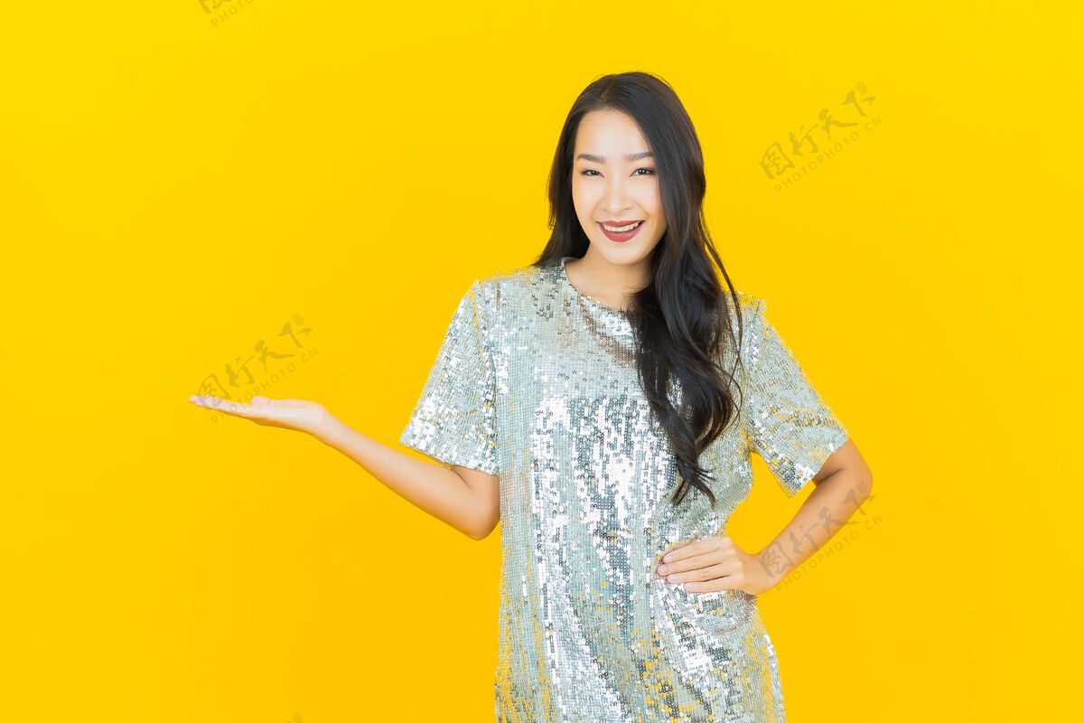 人物肖像美丽的亚洲年轻女子微笑着行动黄色欢乐成人肖像