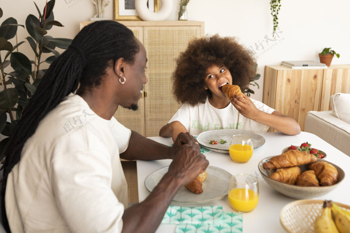 年轻人小女孩和她爸爸一起吃早餐室内活动房子父亲