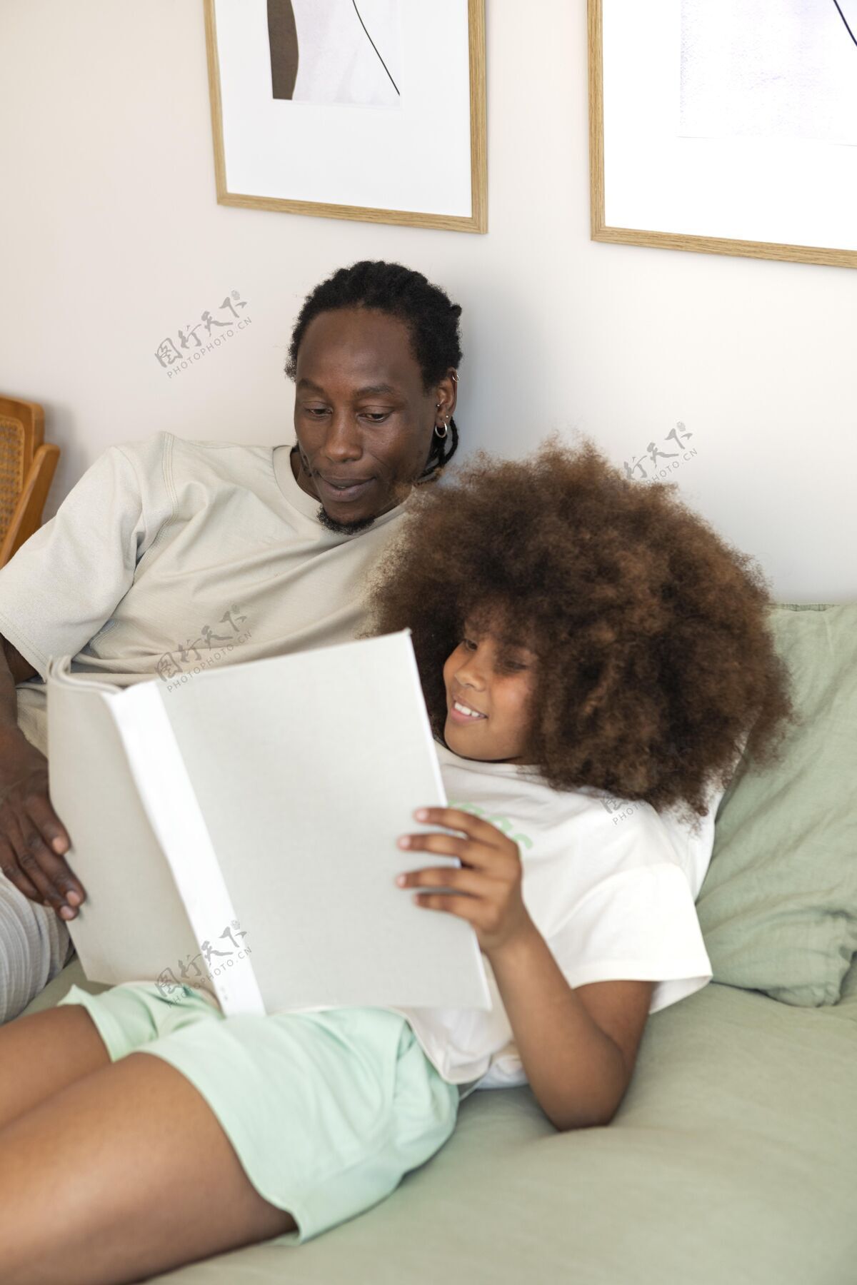 室内女儿和爸爸一起看书娱乐床家庭