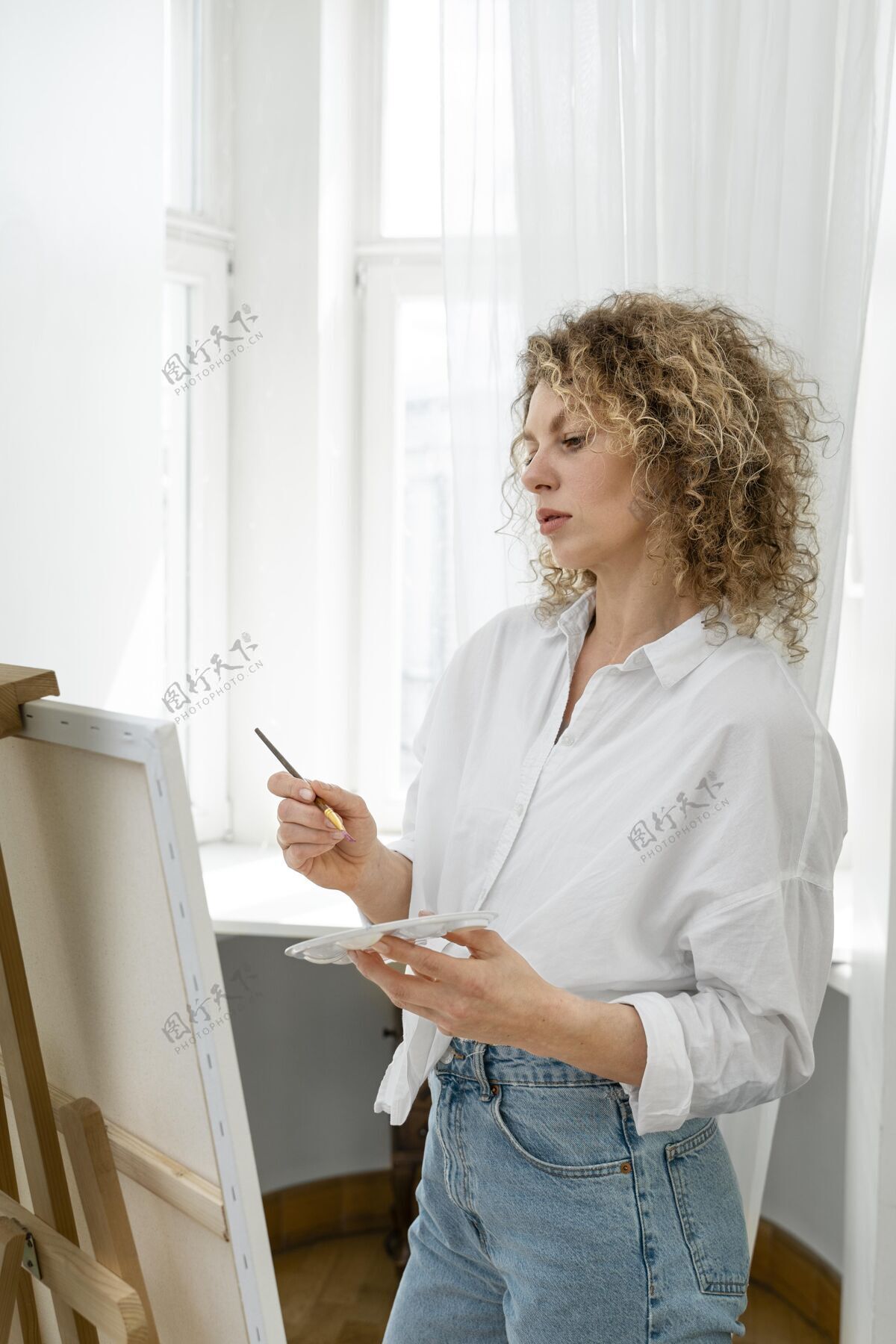 宁静卷发金发女人在家画画垂直女性心灵