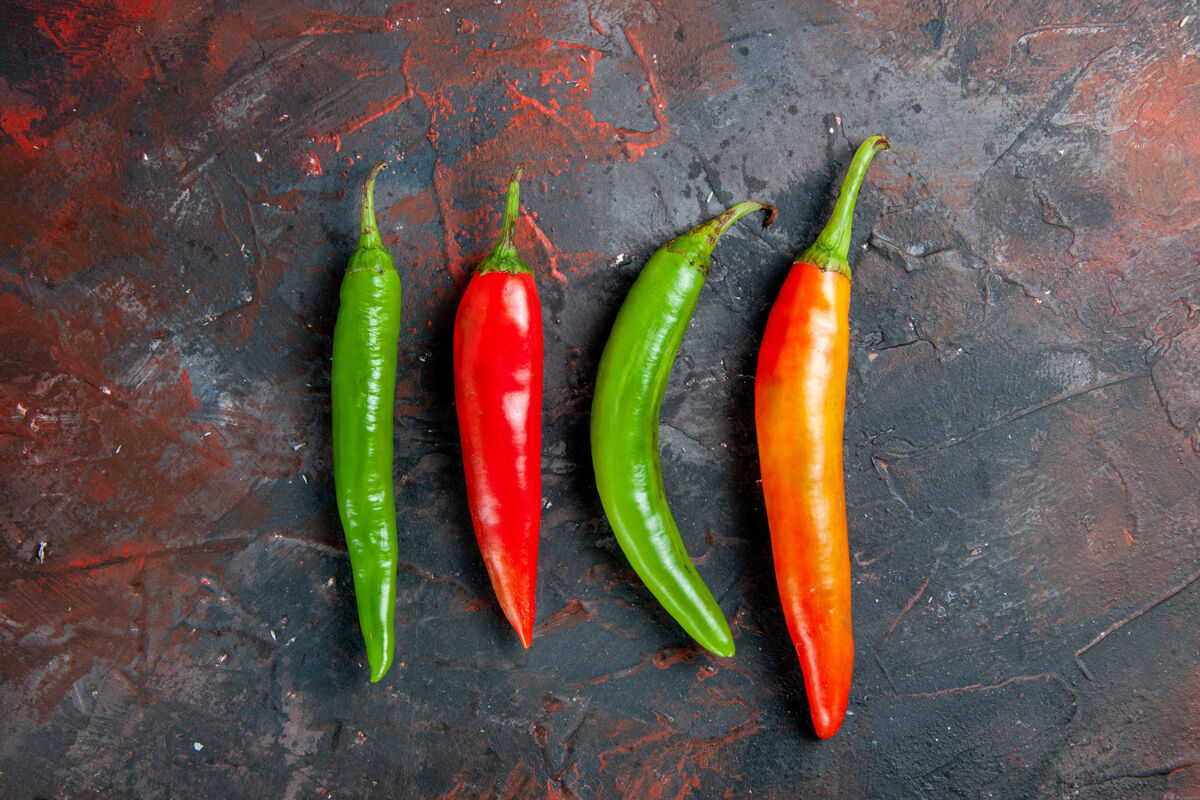 辣椒混合色背景上不同颜色和大小的辣椒顶视图健康新鲜胡椒